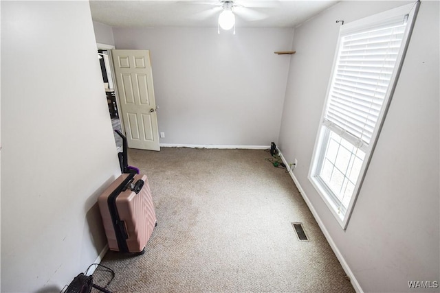 spare room featuring ceiling fan and carpet