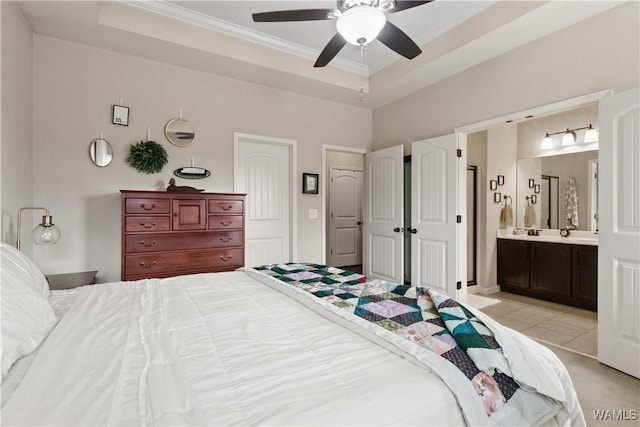 tiled bedroom featuring ornamental molding, connected bathroom, ceiling fan, and a tray ceiling