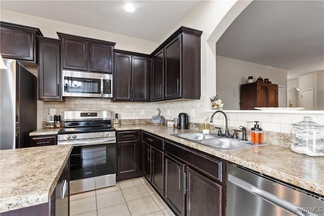 kitchen with sink, tasteful backsplash, dark brown cabinets, light tile patterned floors, and stainless steel appliances