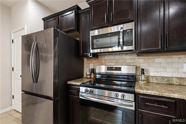 kitchen featuring tasteful backsplash, light tile patterned floors, dark brown cabinetry, stainless steel appliances, and light stone countertops