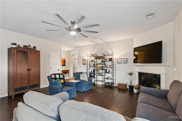 living room with dark hardwood / wood-style flooring and ceiling fan