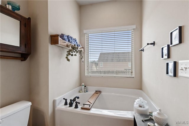 bathroom featuring a tub to relax in and toilet