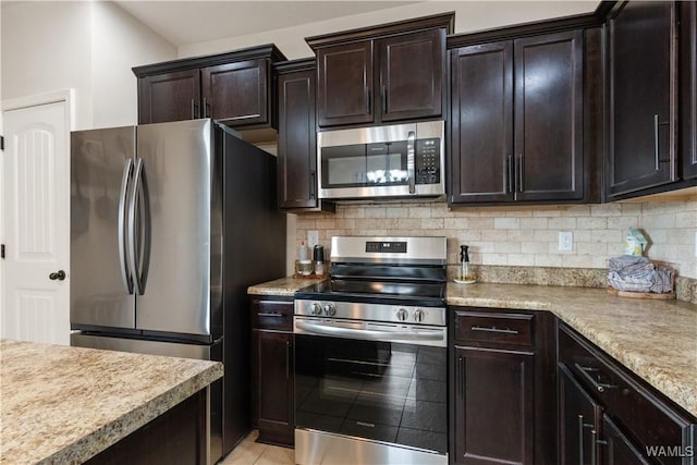 kitchen featuring stainless steel appliances, dark brown cabinets, and backsplash