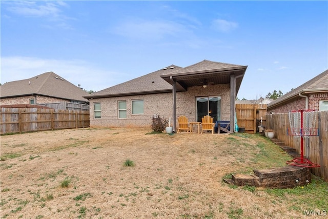 back of house featuring ceiling fan and a lawn