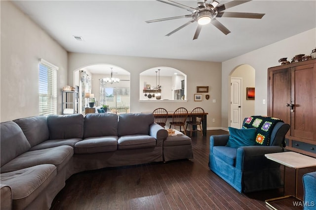 living room with dark hardwood / wood-style flooring and ceiling fan with notable chandelier