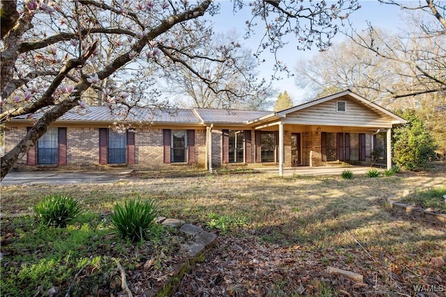 ranch-style house with brick siding and metal roof