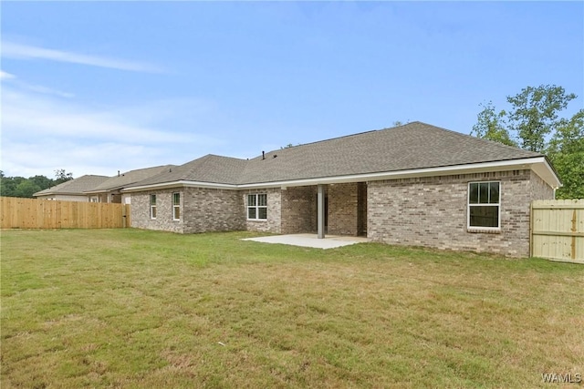 back of house with a patio, a fenced backyard, brick siding, a shingled roof, and a lawn