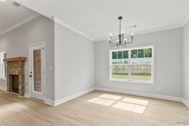 unfurnished dining area with ornamental molding, a notable chandelier, and light wood-style floors