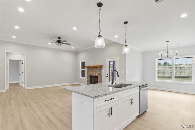 kitchen featuring open floor plan, ornamental molding, a fireplace, and a sink