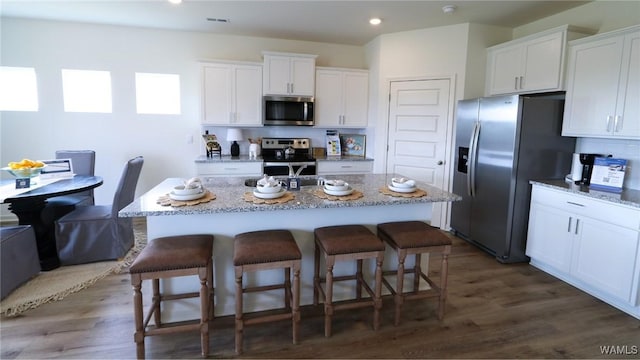 9349 Havenridge Loop, Tuscaloosa, AL 35405 - kitchen featuring appliances with stainless steel finishes, a breakfast bar area, white cabinetry, and recessed lighting