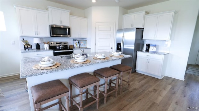 9349 Havenridge Loop, Tuscaloosa, AL 35405 - kitchen with appliances with stainless steel finishes, a sink, white cabinetry, light wood-type flooring, and recessed lighting