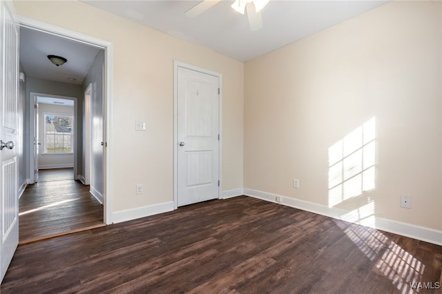 unfurnished bedroom with ceiling fan and dark wood-type flooring