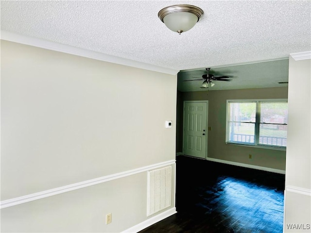 empty room with ornamental molding, dark wood-style flooring, visible vents, and a textured ceiling