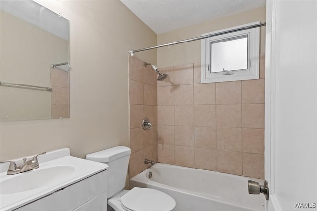 full bathroom featuring vanity, tiled shower / bath combo, a textured ceiling, and toilet