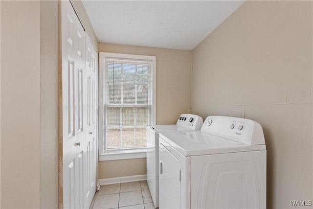 laundry room featuring washing machine and dryer and light tile patterned floors