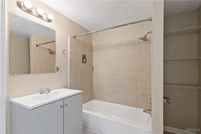 bathroom featuring tiled shower / bath combo and vanity