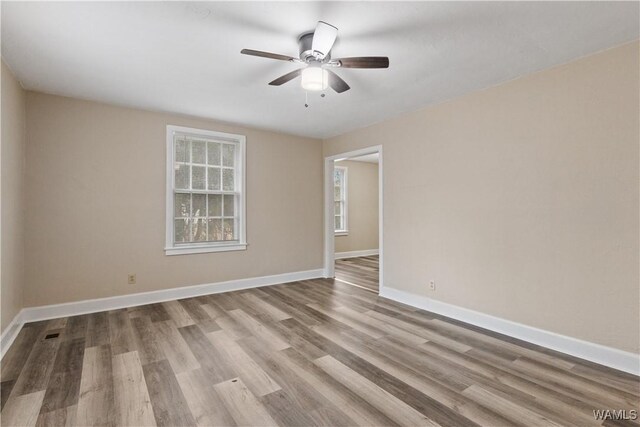 empty room with ceiling fan and light hardwood / wood-style floors