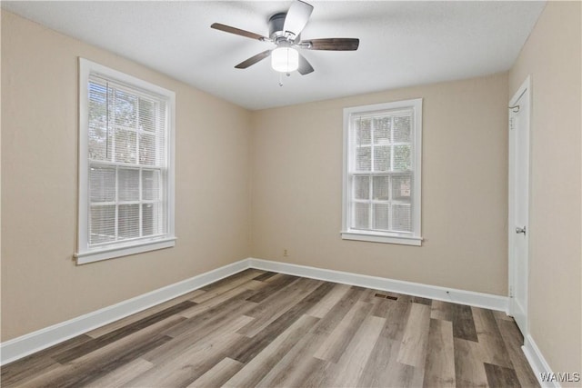 unfurnished room featuring ceiling fan, plenty of natural light, and hardwood / wood-style floors