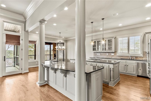 10416 Harbourtowne Dr, Northport, AL 35475 - kitchen featuring ornate columns, an island with sink, appliances with stainless steel finishes, wood finished floors, and recessed lighting