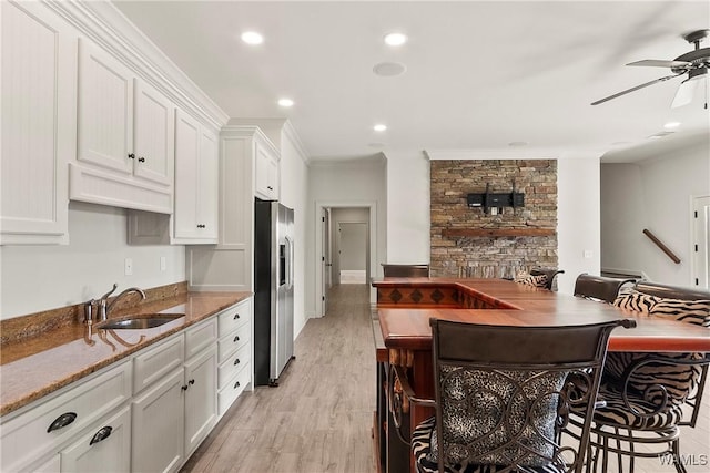 10416 Harbourtowne Dr, Northport, AL 35475 - kitchen featuring stainless steel fridge with ice dispenser, a ceiling fan, white cabinets, stone countertops, and ornamental molding