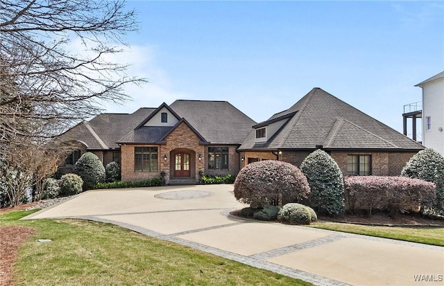 10416 Harbourtowne Dr, Northport, AL 35475 - view of front facade featuring brick siding, curved driveway, and roof with shingles