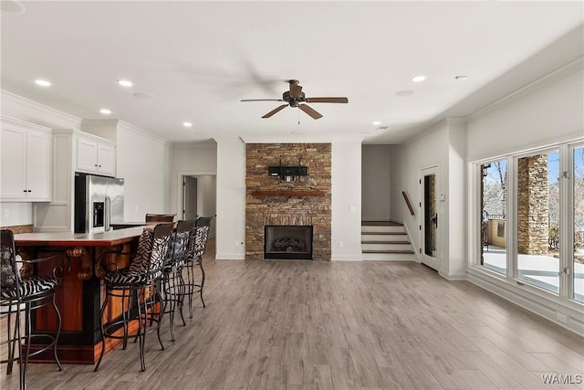 10416 Harbourtowne Dr, Northport, AL 35475 - kitchen featuring stainless steel fridge with ice dispenser, ornamental molding, a kitchen bar, a ceiling fan, and white cabinets