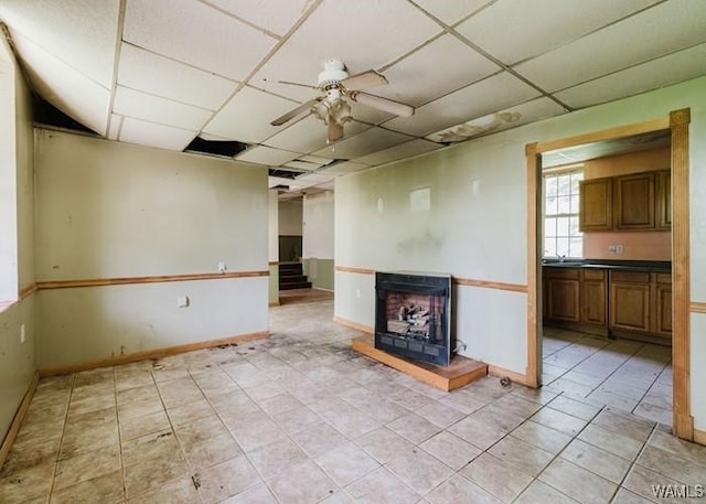 120 John Watkins Ln, Dora, AL 35062 - unfurnished living room featuring a sink, light tile patterned floors, a ceiling fan, baseboards, and a drop ceiling