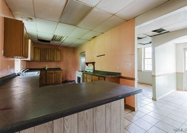 120 John Watkins Ln, Dora, AL 35062 - kitchen featuring white gas range, dark countertops, a peninsula, and a paneled ceiling