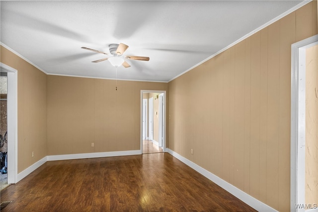 spare room with ceiling fan, wood walls, ornamental molding, and dark wood-type flooring