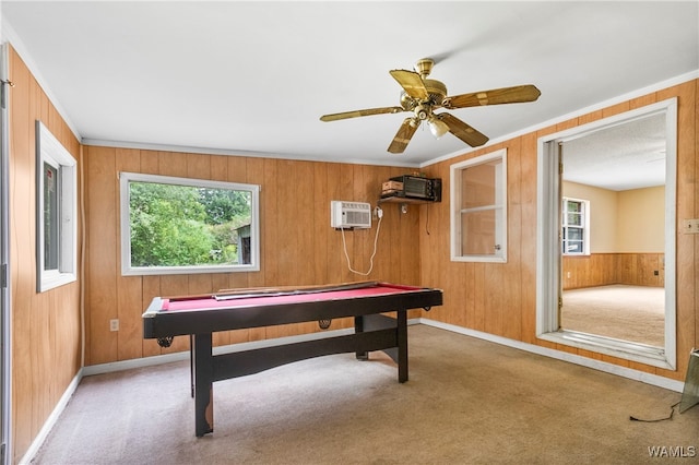 playroom featuring carpet floors, a wealth of natural light, wooden walls, and ceiling fan