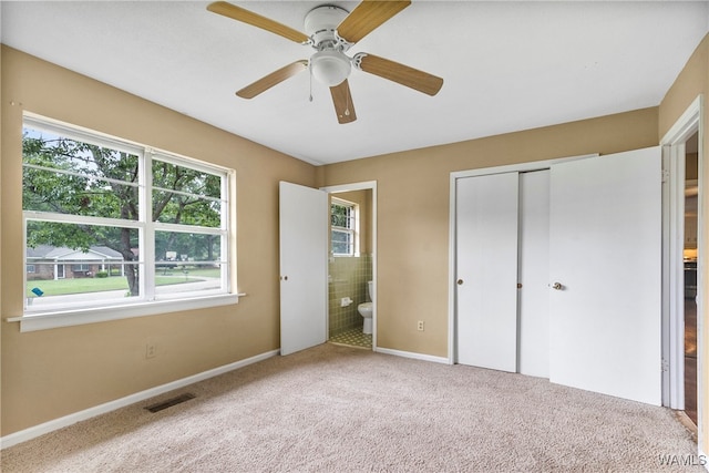 unfurnished bedroom with ceiling fan, carpet floors, connected bathroom, and a closet