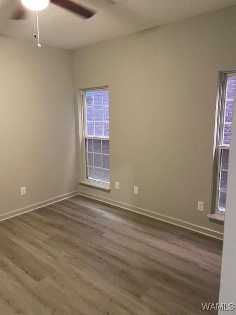 empty room featuring hardwood / wood-style floors, a wealth of natural light, and ceiling fan