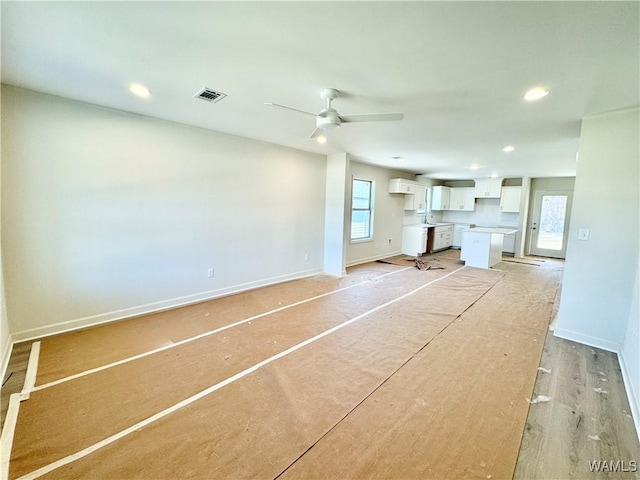 unfurnished living room with ceiling fan