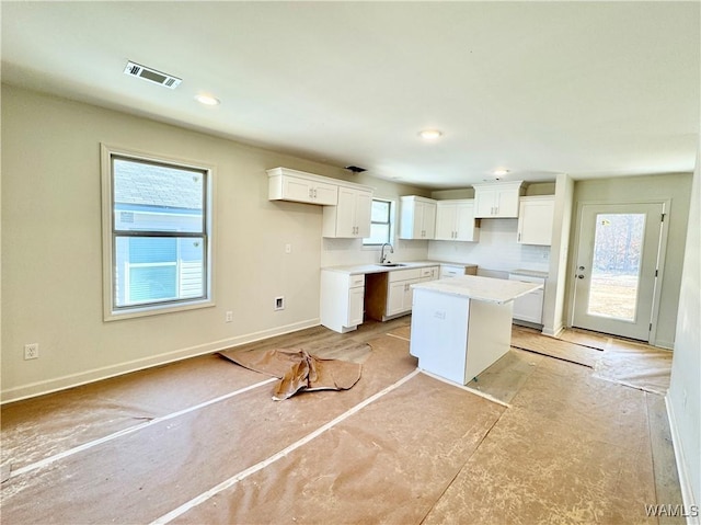 kitchen featuring sink, a center island, and white cabinets