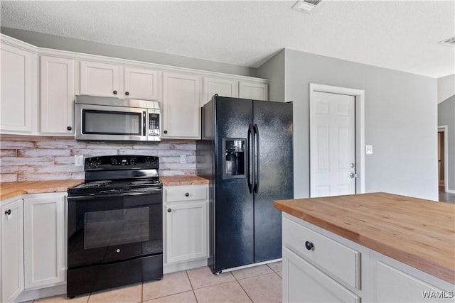 kitchen with tasteful backsplash, butcher block counters, light tile patterned floors, white cabinets, and black appliances