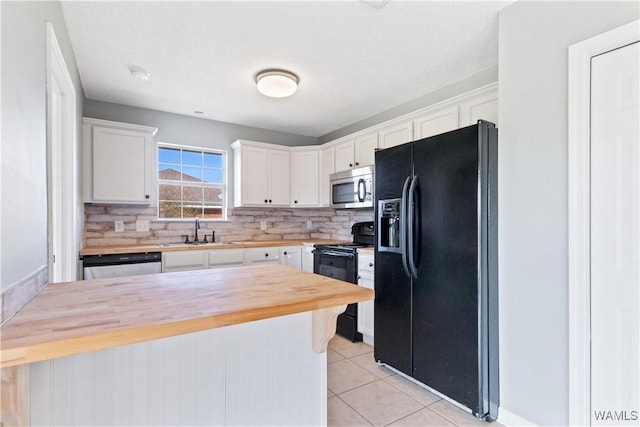 kitchen with light tile patterned floors, wooden counters, decorative backsplash, black appliances, and white cabinets