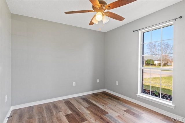 spare room featuring a ceiling fan, baseboards, and wood finished floors