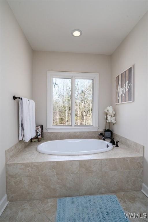 bathroom featuring tile patterned floors and tiled tub