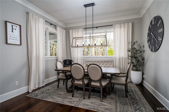 dining area with dark hardwood / wood-style floors, ornamental molding, and an inviting chandelier