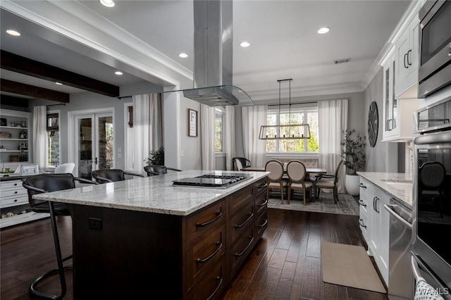 kitchen featuring stainless steel appliances, island range hood, white cabinets, dark hardwood / wood-style floors, and a kitchen island