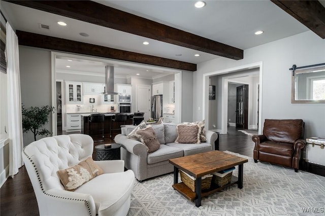 living room featuring beam ceiling and light hardwood / wood-style flooring