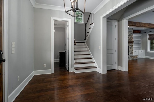 entrance foyer featuring wood-type flooring, ornamental molding, baseboards, stairway, and a notable chandelier