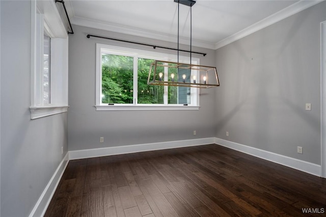 unfurnished dining area featuring crown molding, dark wood finished floors, baseboards, and a chandelier