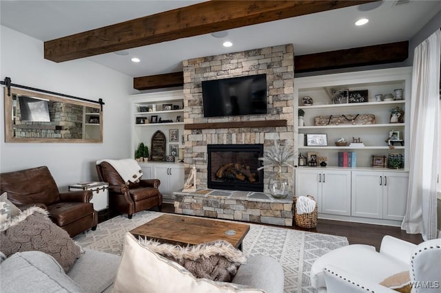 living room featuring beam ceiling, a fireplace, built in features, and wood-type flooring