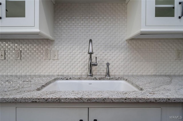 interior details featuring a sink and tasteful backsplash