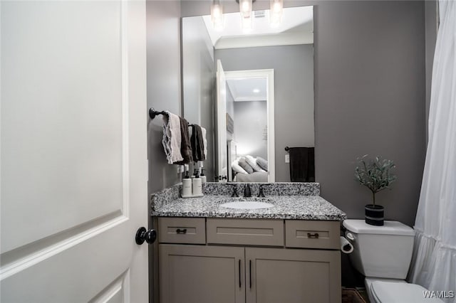 bathroom featuring vanity, toilet, and ornamental molding