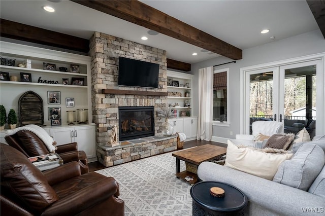 living room featuring a fireplace, hardwood / wood-style floors, built in features, and french doors