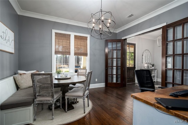 dining space featuring french doors, an inviting chandelier, dark wood-type flooring, and crown molding