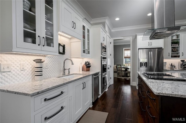 kitchen with sink, light stone counters, island exhaust hood, white cabinets, and appliances with stainless steel finishes