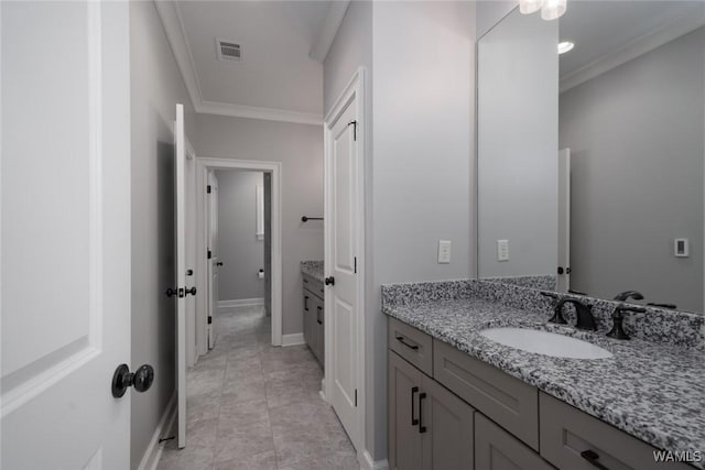 bathroom featuring vanity, ornamental molding, baseboards, and visible vents